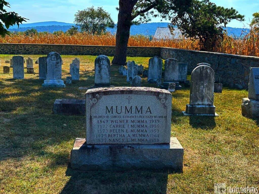 Cemetery with a prominent gravestone labeled "Mumma" and several other gravestones in a field.