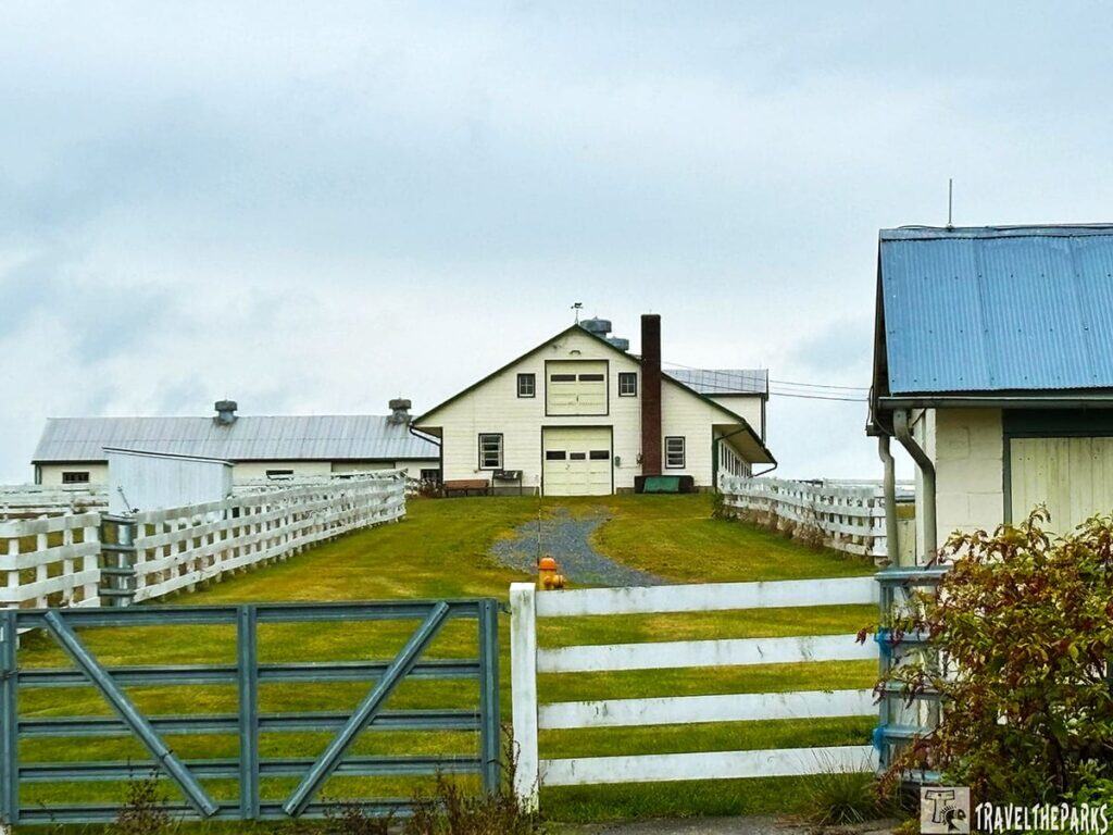 Eisenhower's Aberdeen Angus cattle Show Barn with white fences and overcast sky.
