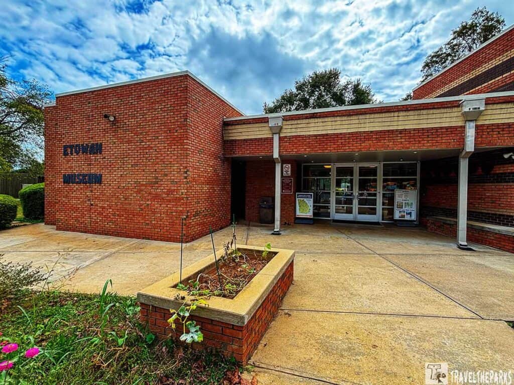 Exterior view of the Etowah Museum with brick walls and glass entrance.

