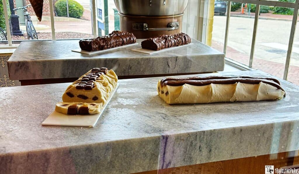 A display of varied fudge types on a polished stone countertop in a shop.