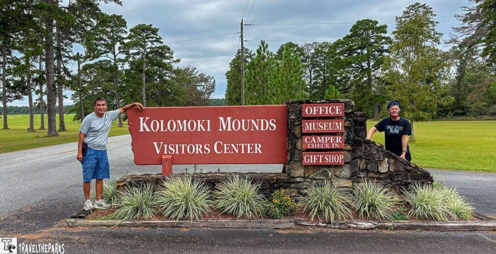 Entrance sign for Kolomoki Mounds Visitors Center with two people posing.

