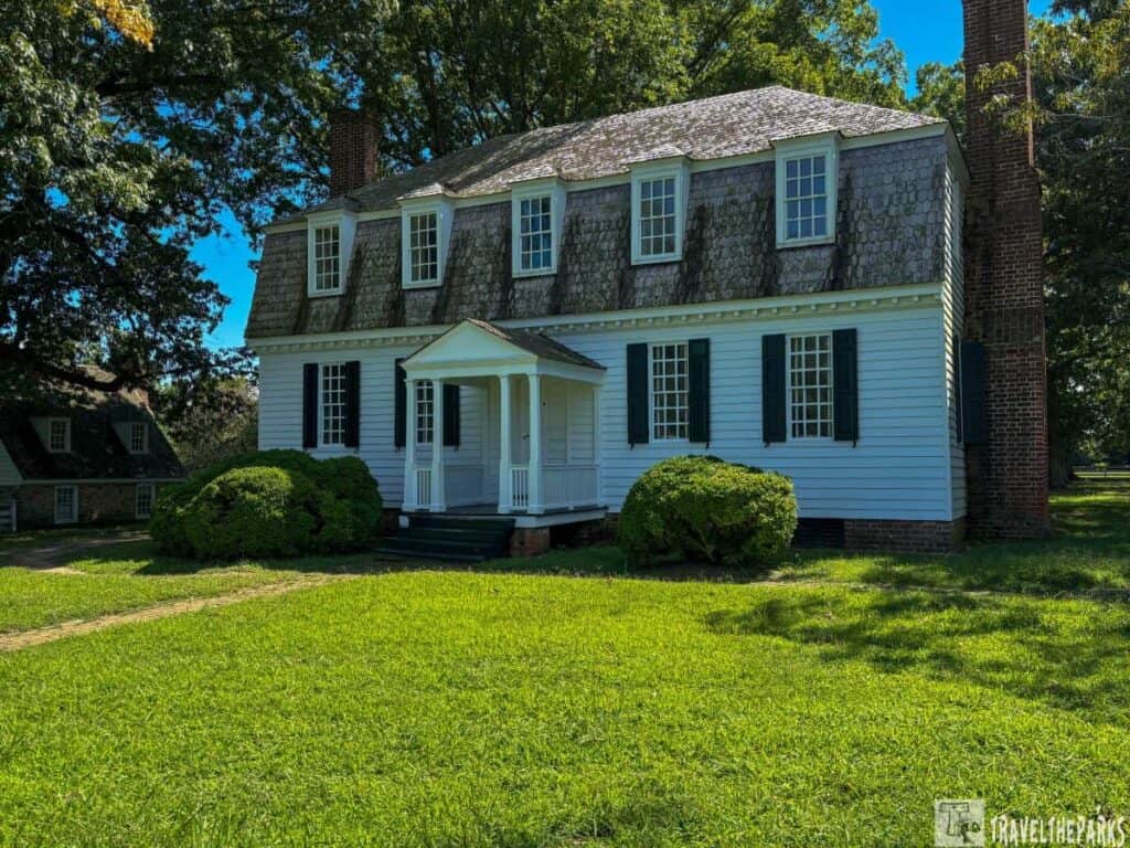 The Moore House on the Yorktown Battlefield, a colonial-style white house with a steep roof and central porch, surrounded by a lawn and trees.
