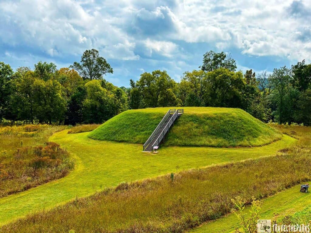 A large grass-covered mound B with a staircase and surrounding trees at Etowah Mounds.

