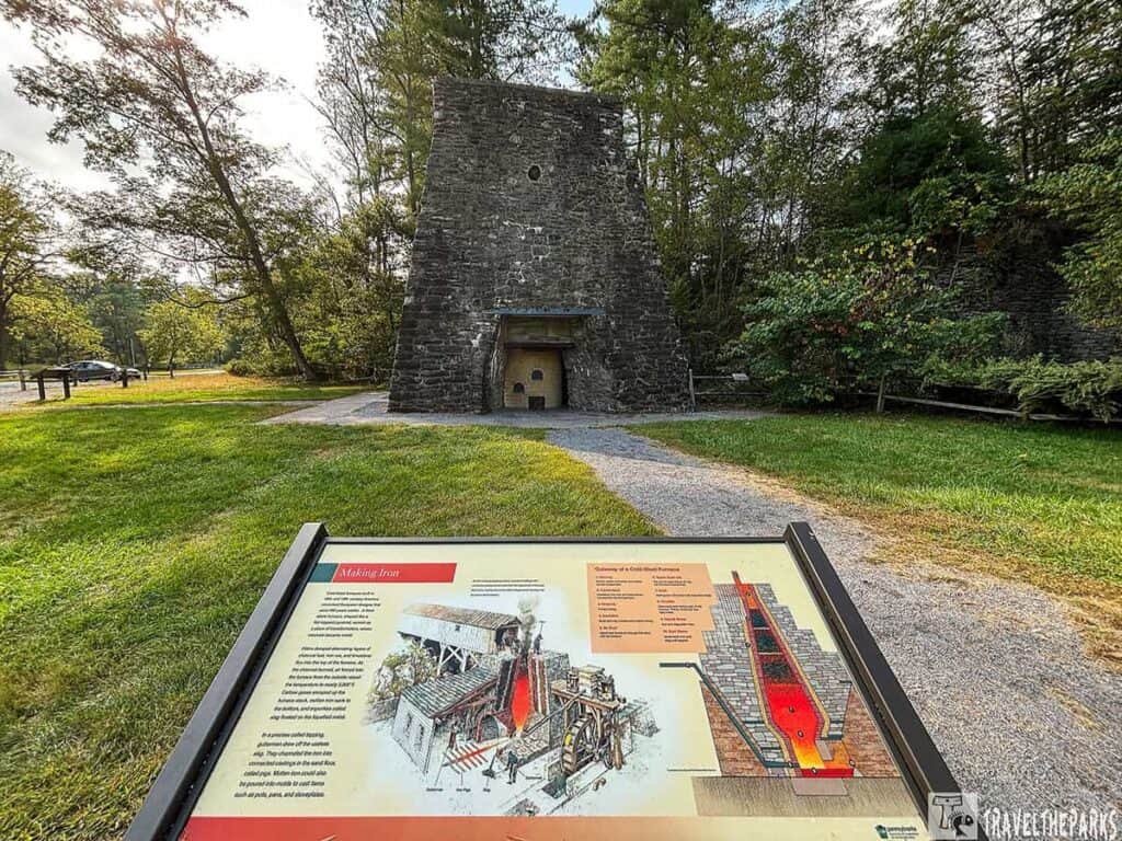 A historical stone furnace at Pine Grove Furnace State Park with an informational sign in the foreground.


