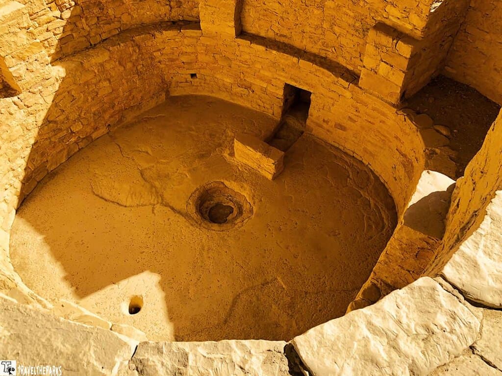 Ancient circular stone kiva structure viewed from above with a central depression and high sandstone walls at Balcony House