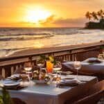 A beachside restaurant with a table and chairs set up on the sand, surrounded by ocean waves and a clear blue sky.