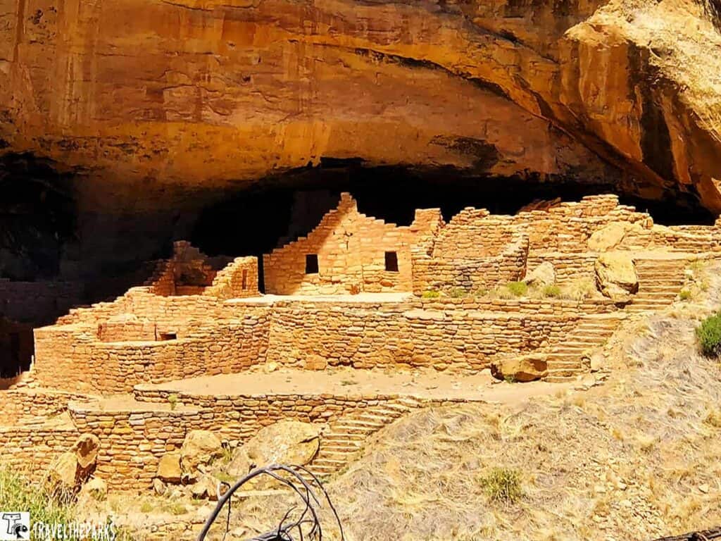 Stone ruins of Long House at Mesa Verde under a large rock overhang.

