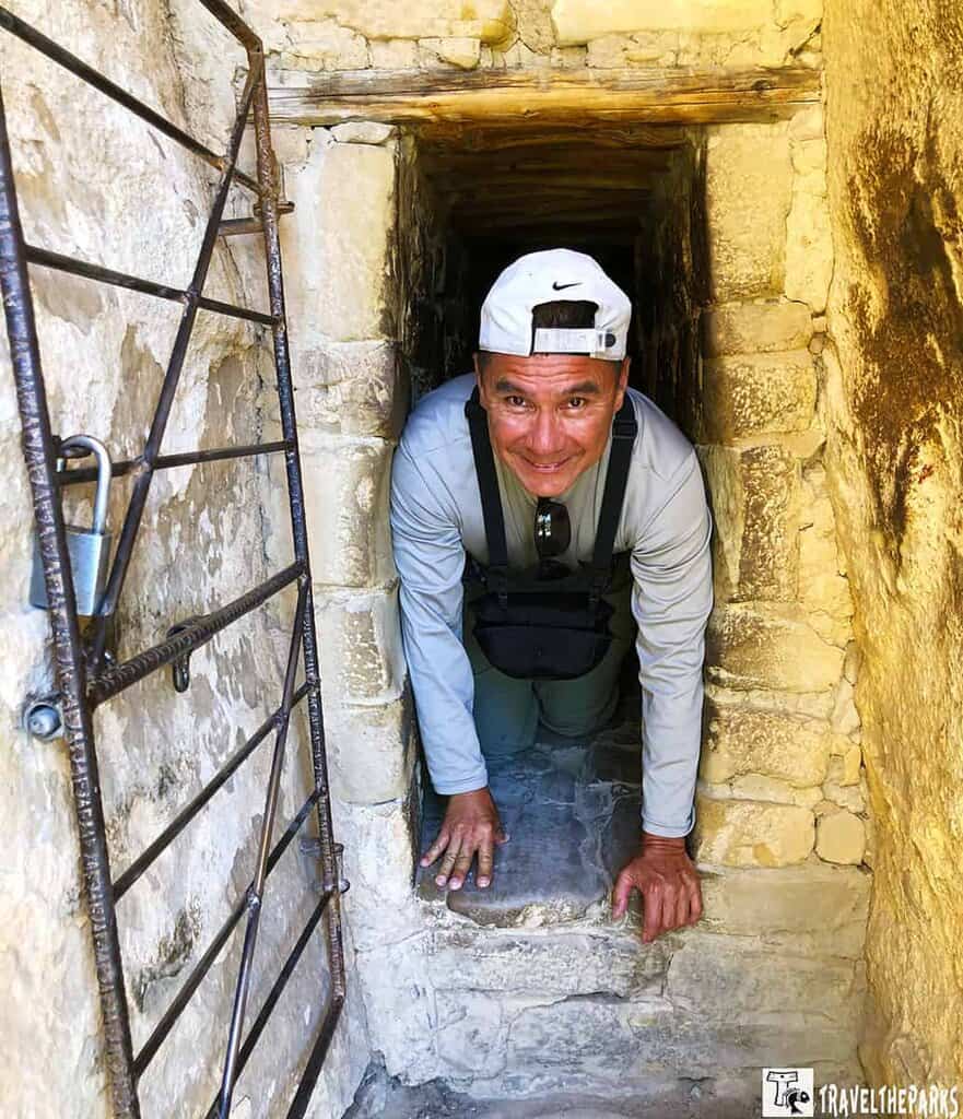 Man crawling through the tunnel at Balcony House in Mesa Verde National Park