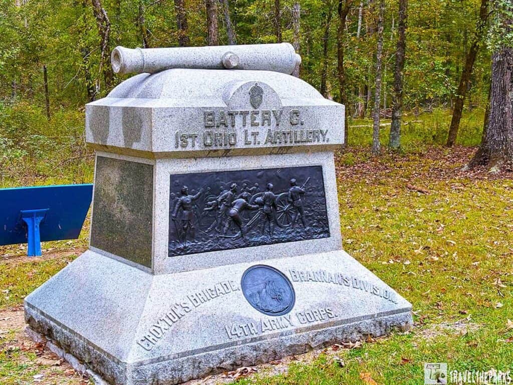 Monument for 1st Ohio Light Artillery, Battery C, with a cannon relief and cannon sculpture on top, located in a wooded park area.

