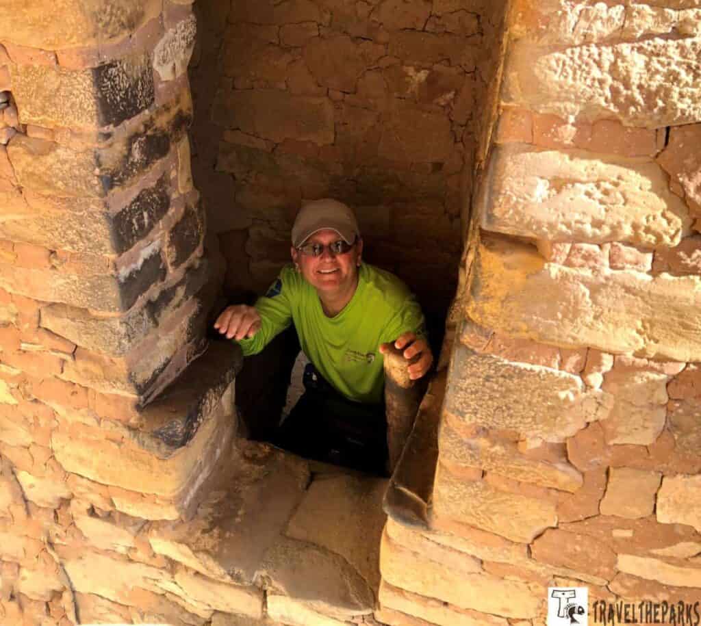 person climbing a ladder at Balcony House in Mesa Verde.