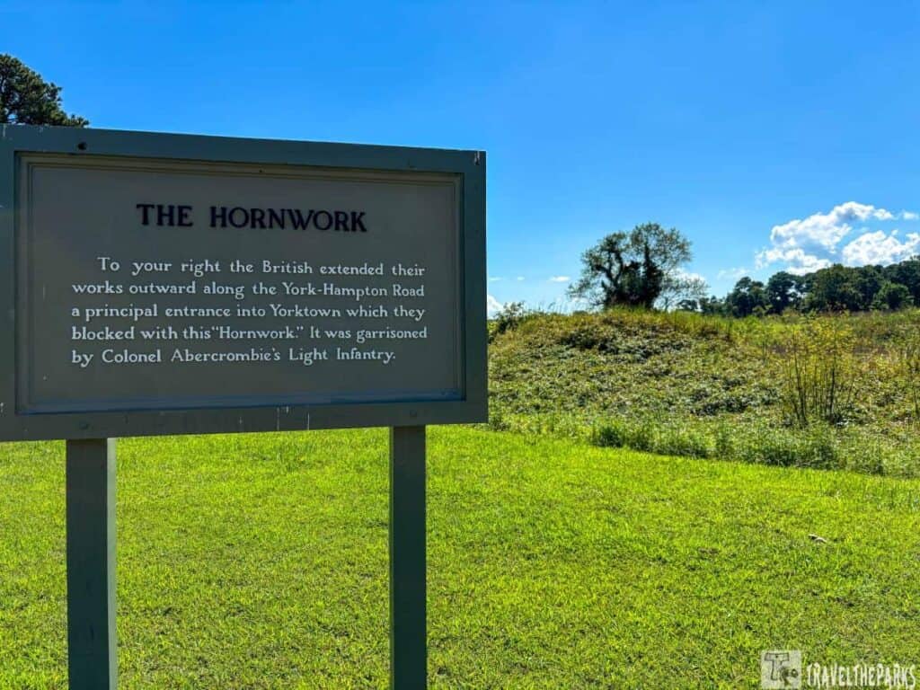 Informational sign about "The Hornwork" against a grassy landscape and blue sky at Yorktown Battlefield Driving Tour Stop A.