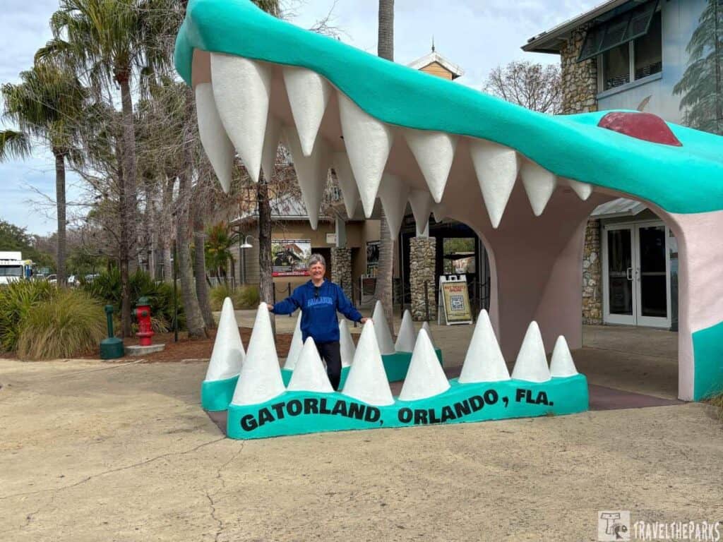 Person standing inside a large alligator mouth structure at Gatorland Orlando.

