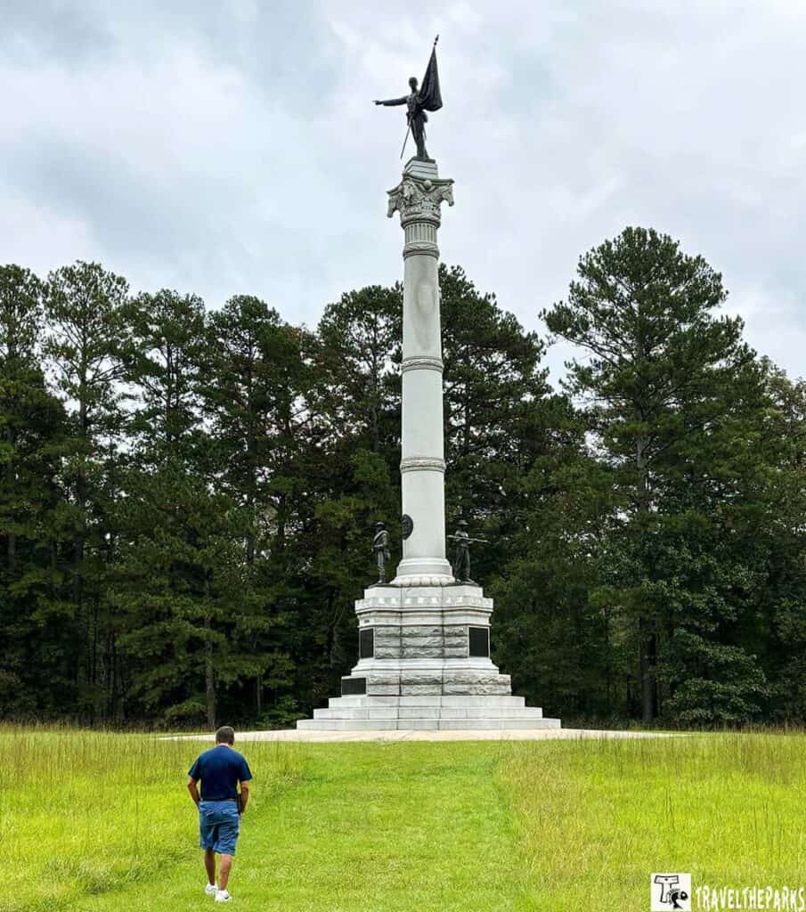 Georgia Monument with a tall column topped by a statue, surrounded by trees.

