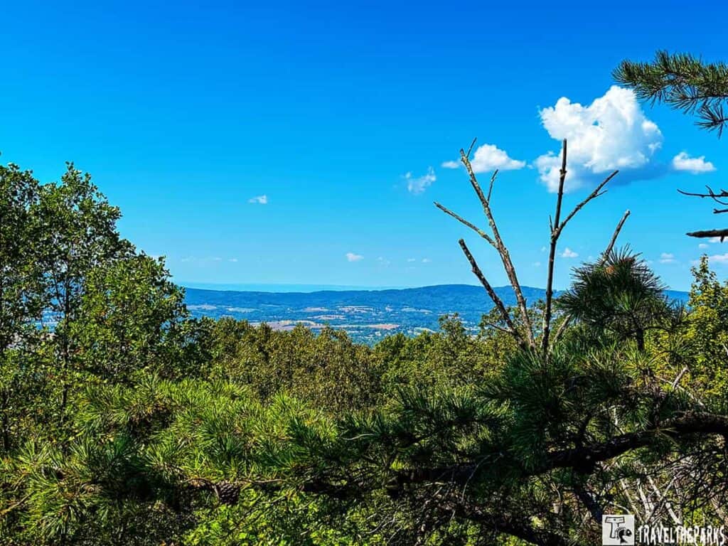 View from Gambrill State Park High Knob Overlook with green trees, distant hills, and a blue sky.