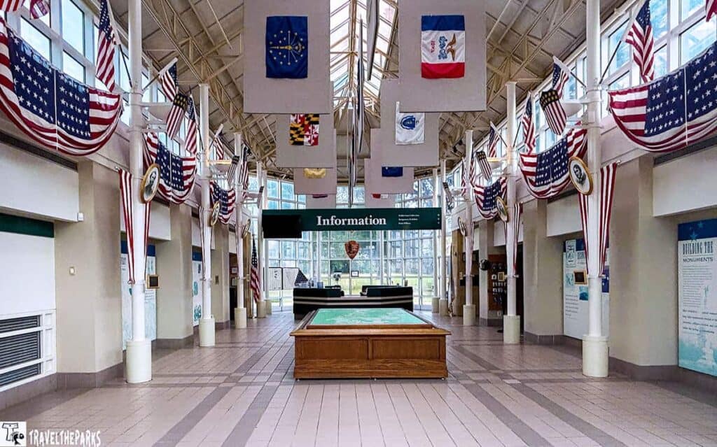 Interior of the Chickamauga Battlefield Visitor Center with flags, an information desk, and a display table.
