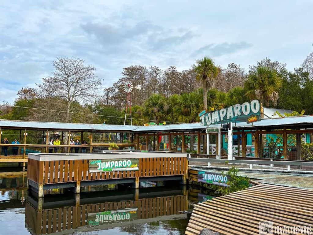 Outdoor exhibit area at Gatorland Orlando with wooden platforms and a "Gator Jumparoo Show" sign.

