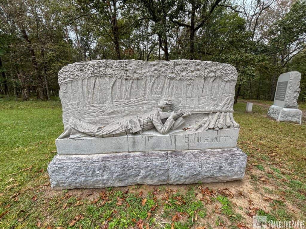 Carved stone monument of the 15th U.S. Infantry at Chickamauga, depicting a soldier aiming a rifle in a forest.

