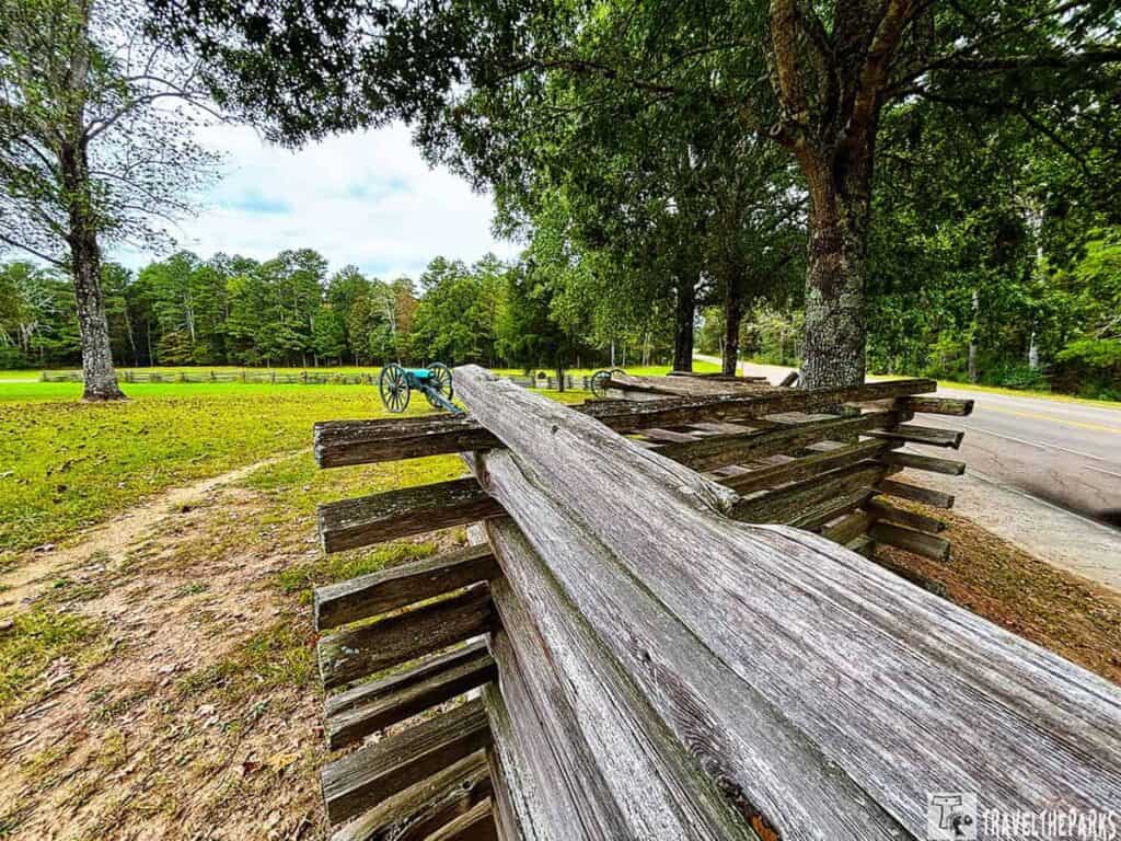 Wooden split-rail fence and teal cannon at Chickamauga Battlefield.

