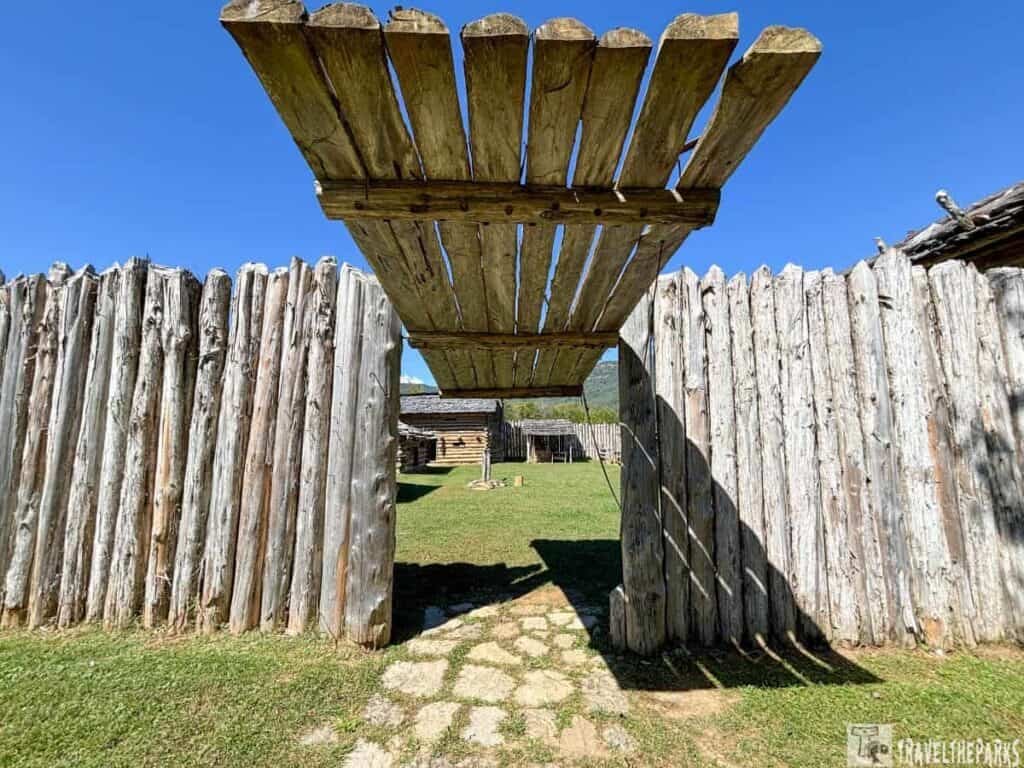 Wooden entrance gate at Martin Station with a log cabin and clear sky background.