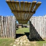 Wooden entrance gate at Martin Station with a log cabin and clear sky background.