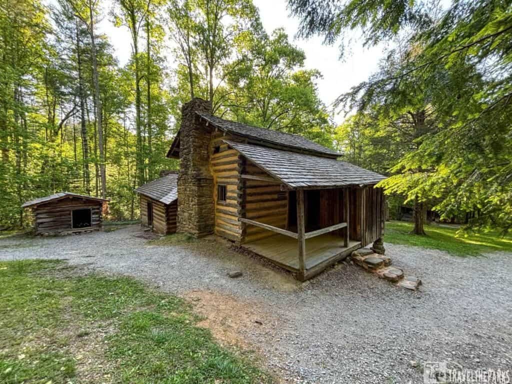 Elijah Oliver Place in Cades Cover. Historic log cabin with stone chimney in a wooded setting.

