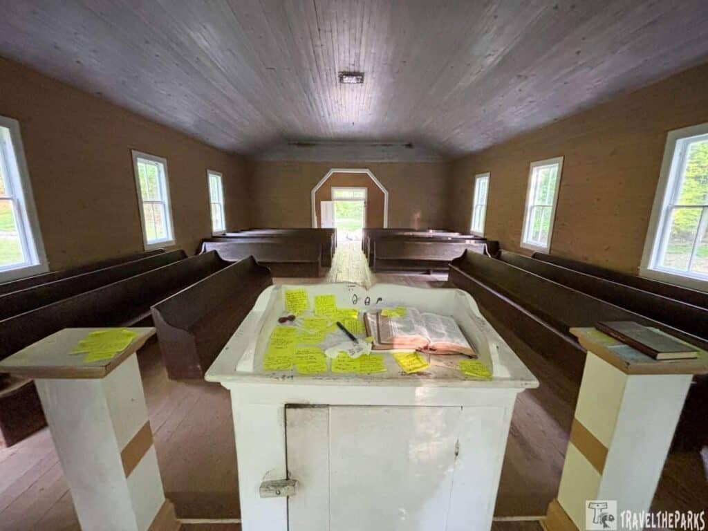 Interior of Missionary Baptist Church with wooden pews and a white pulpit at the front.

