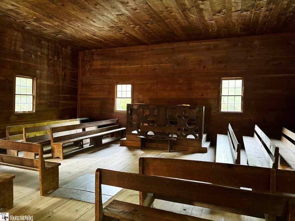 Interior of an old wooden church with pews and a pulpit.

