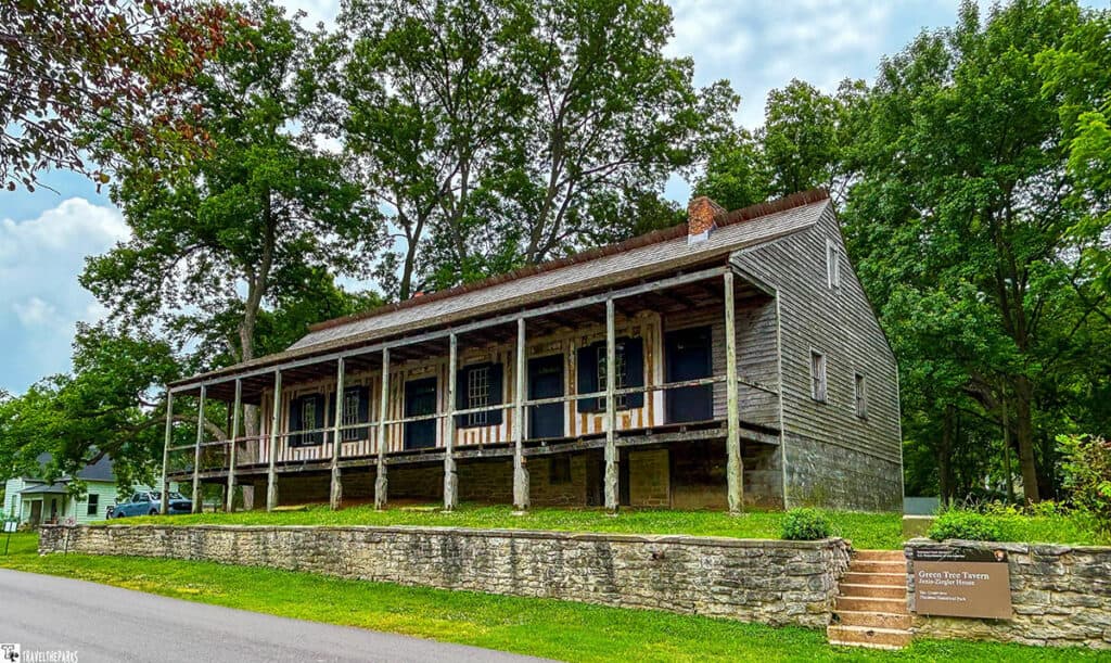Historic Green Tree Tavern at Ste. Geneviève National Historic Site, featuring wooden architecture, porches, and a stone wall.