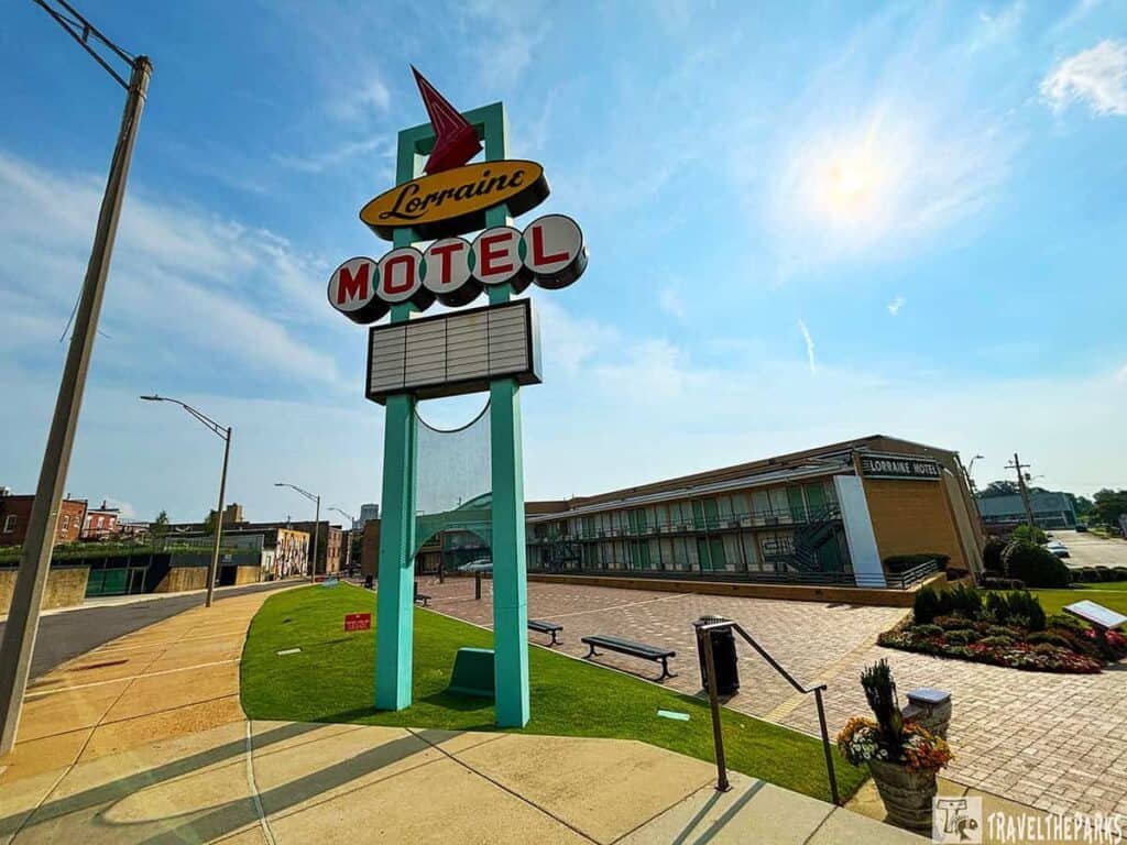 Exterior view of the Lorraine Motel with a retro sign, showcasing a turquoise structure and mid-century architecture under a partly cloudy sky.
