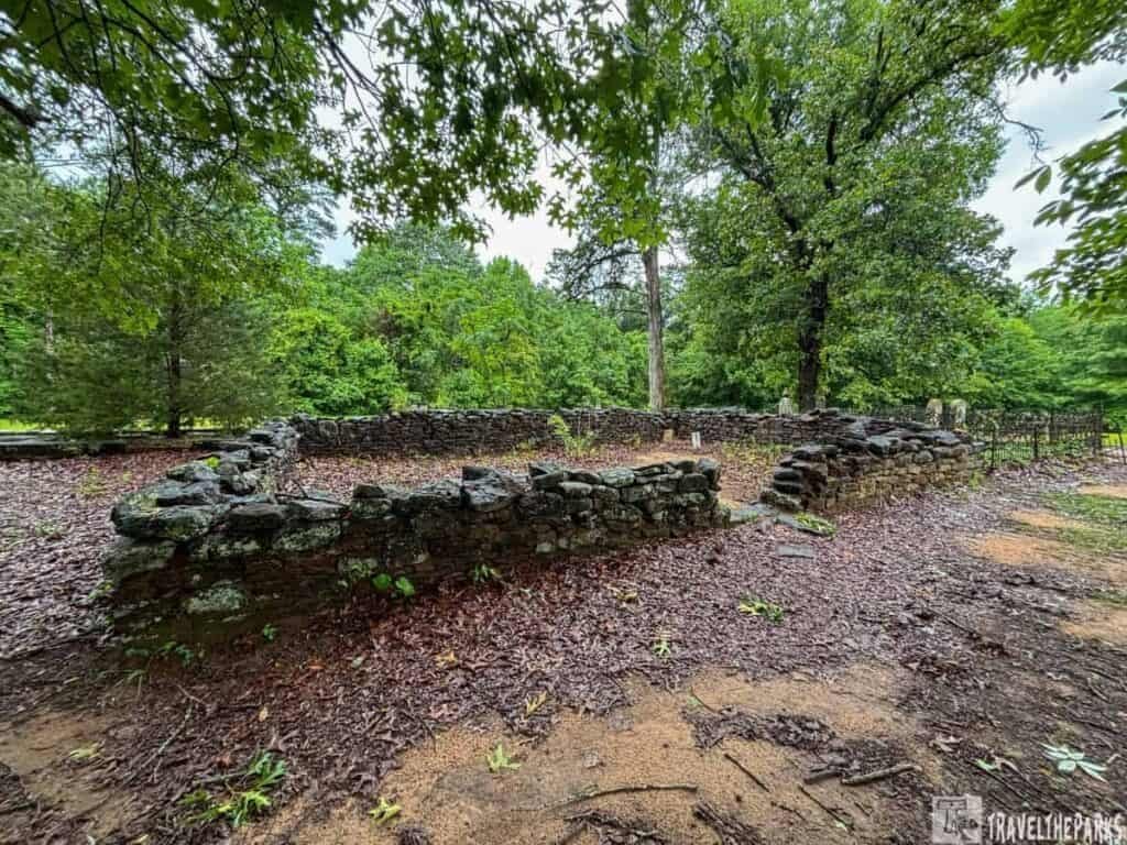 Old stone ruins surrounded by a dense forest.