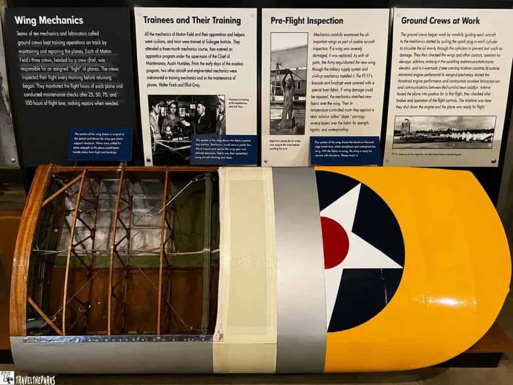 A detailed section of an aircraft wing with exposed interior supports, and informational panels about aircraft mechanics, training, inspections, and ground crew operations at the Tuskegee Airmen National Historic Site.

