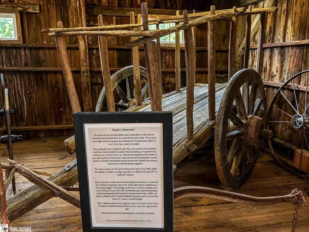 An old wooden cart, known as a charrette, is displayed in Ulysses S. Grant's office, with a black informational sign explaining its significance. The rustic wooden interior is illuminated by natural light from a window.

Transcribed Text:

Grant's Charette?

The style of cart you see before you is indicative of the French Charettes that graced early U.S. Louis streets and roads. They are light, strong, and very suitable for hauling heavy loads of corn, hay, wood, or people.

This particular cart is made of oak. The cart consists of slats that form the bed with the center board creating a long flat surface to hold the loads to from both vertical and horizontal movement when in contact with other products. Wheels allow the cart to be moved freely.

The upper portion of the cart is believed to date circa 1830, while the wheels and hitch are attributed to the latter part of the 19th or early 20th century.

Much has been written about Grant’s charrette used to haul goods. Scholars have identified it mainly as what Mr. Scharf’s History of St. Louis City and County called it, including references to the historical use of this particular charrette.

[i] Scharf’s source for this information is not clear.

All of the wood for this cart is believed to have been sourced from Deville’s Planting, St. Louis at the local yard.