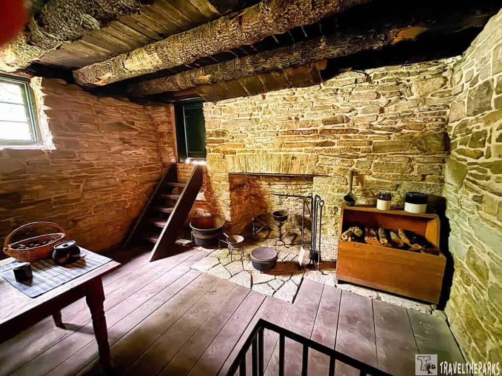 Interior view of Ulysses S. Grant's office, featuring stone walls, wooden beams, a staircase, and a fireplace with rustic furniture.