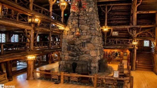 Interior of Old Faithful Inn with its large stone fireplace, rustic timber beams, and historic lodge design